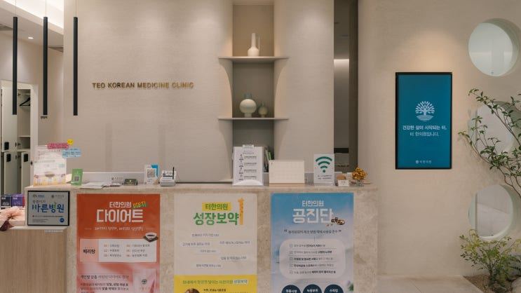 안내 포스터가 붙은 한의원 접수대