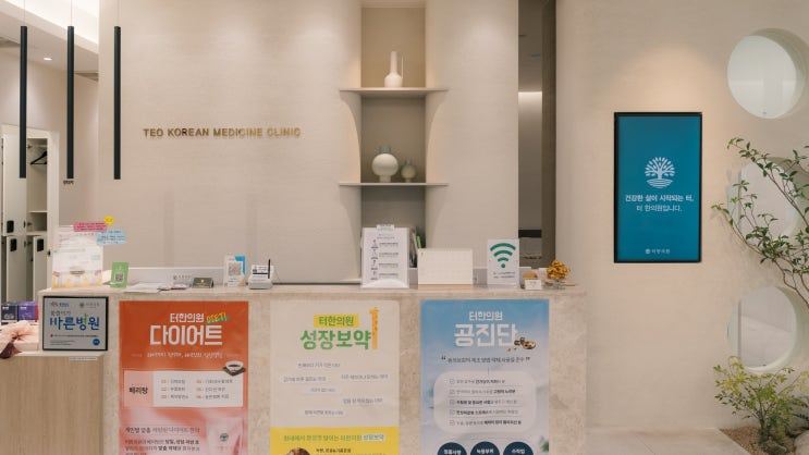 안내 포스터가 붙은 한의원 접수대