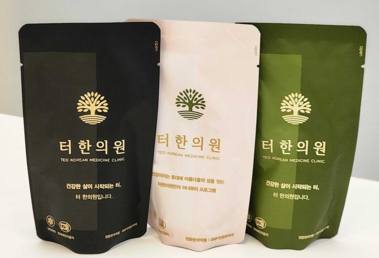 터한의원 로고가 인쇄된 검정색, 연분홍색, 녹색 한약 파우치 세 개
